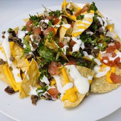 Nachos: choice of meat,(asada, al pastor, carnitas , chicken, chorizo) pico de gallo, nacho cheese, sour cream, and black beans