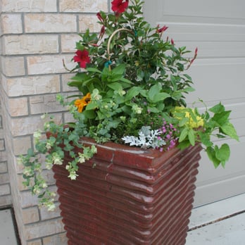 Peterson Lawn Services - a planter with flowers in front of a garage door - Snow Removal Near Me Peterson Lawn Services - a planter with flowers in front of a garage door - Snow Removal Near Me
