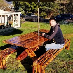OCD Construction - Seth sitting on a custom made table and bench that he and his team built.