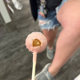 a person holding a donut with a heart on it a person holding a donut with a heart on it