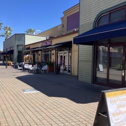 Outside, deep inside the shopping plaza. Across from the board game shop.