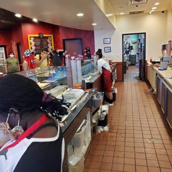 Cold Stone Creamery - Trash on the floor, something leaking out of trash, staff with her elbows on the food prep surface - Ice Cream & Frozen Yogurt Near Me - Herndon, Virginia