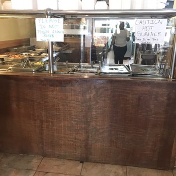 J&M Kelly's - a man standing in front of the counter - Caribbean Near Me - Queens, New York
