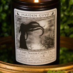 Carpe Noctem Candle - The Maiden Guyo Candle captures grace and strength in equal measure. Its fragrance of patchouli, rose, pepper, dark rose, and...