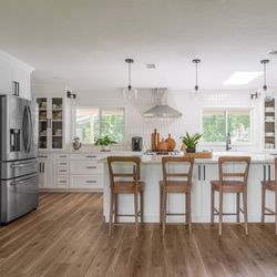 Details Construction Group - Beautiful open and airy kitchen remodel by Details Construction Group. Featuring sleek wood floor, white cabinets, and bold black hardware.