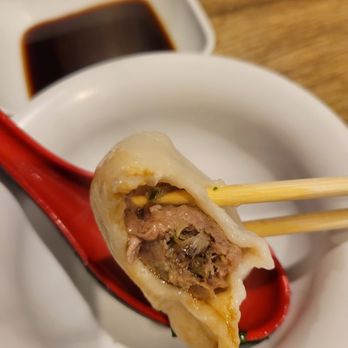 Tianjin Dumplings Restaurant - a close up of a dumpling with chopsticks - Chinese Near Me - Scarborough, Ontario Tianjin Dumplings Restaurant - a close up of a dumpling with chopsticks - Chinese Near Me - Scarborough, Ontario