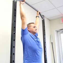 Xcel Movement And Performance - Donald working one on one with one of our performance therapists on his shoulder position for pain free pull ups during his work outs.