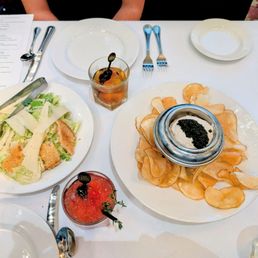 Caesar salad, cocktails, and caviar with chips and dip