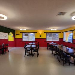 Pollitos Authentic Grilled Chicken - View of larger dining area from the restroom hallway.