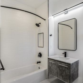 Pro Tile Specialists - a bathroom with a tub, sink, and mirror - General Contractors Near Me Pro Tile Specialists - a bathroom with a tub, sink, and mirror - General Contractors Near Me