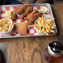 Three-piece dark chicken with mac & cheese, cornbread, fries, and a biscuit.