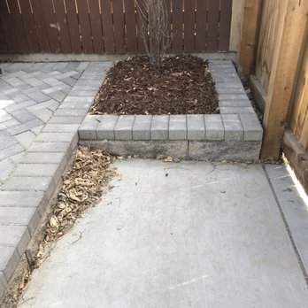 Evolution Landscape and Design - a concrete patio with a planter - Landscaping Near Me