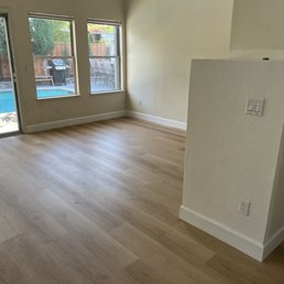 an empty living room with a pool in the background