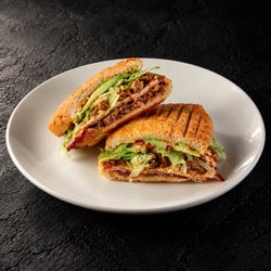 Fuego Cravings - Tantalize your taste buds with milanesa de res, ham, and carne asada layered with panela, tomato, lettuce, beans, onion, avocado, FC spread