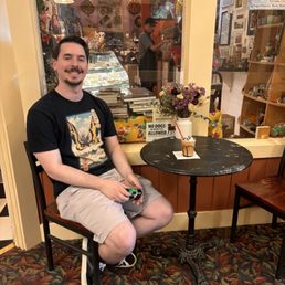 Husband with iced cappuccino on the cute table outside of the shop Husband with iced cappuccino on the cute table outside of the shop