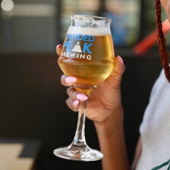 Banded Peak Brewing - a woman holding a glass of beer - Breweries Near Me - Calgary, Alberta