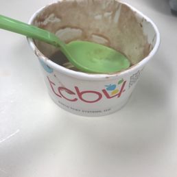 a cup of yogurt with a green spoon a cup of yogurt with a green spoon