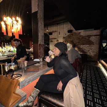 Jolie - a woman sitting at a bar drinking a beverage - Cocktail Bars Near Me - New Orleans, Louisiana Jolie - a woman sitting at a bar drinking a beverage - Cocktail Bars Near Me - New Orleans, Louisiana