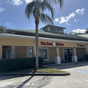 Dim Sum Kitchen - The image shows the storefront of Dim Sum Kitchen in Bradenton, FL, with signage, parking spaces, and palm trees in front. - Dim Sum Near Me - Bradenton, Florida