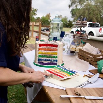 Frost It Cakery - a woman cutting a rainbow cake - Bakeries Near Me - Thousand Oaks, California Frost It Cakery - a woman cutting a rainbow cake - Bakeries Near Me - Thousand Oaks, California