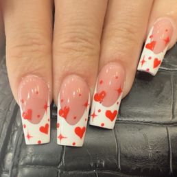Dip powder manicure with French tip and heart and sparkle design