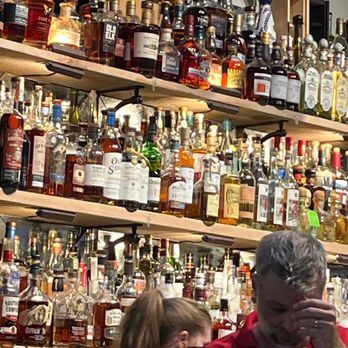 Diversion Pizza - a man and a woman standing in front of a wall of liquor bottles - Pizza Near Me - Maurepas, Louisiana Diversion Pizza - a man and a woman standing in front of a wall of liquor bottles - Pizza Near Me - Maurepas, Louisiana