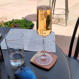 a glass of champagne and a mouse on a table a glass of champagne and a mouse on a table