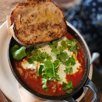 Gjelina - Moroccan Baked Eggs, Merguez, Tomato Sauce, Cilantro, Spiced Yogurt - New American Near Me - Venice, California Gjelina - Moroccan Baked Eggs, Merguez, Tomato Sauce, Cilantro, Spiced Yogurt - New American Near Me - Venice, California