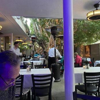 John Henry's - a man sitting at a table in a restaurant - American Near Me - Palm Springs, California John Henry's - a man sitting at a table in a restaurant - American Near Me - Palm Springs, California