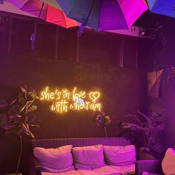 Pearl Bar - a couch and umbrellas lit up at night - Bars Near Me - Houston, Texas
