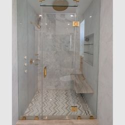 Grandmaster's Glass & Mirrors - Frameless steam shower enclosure in 3/8" clear tempered glass with satin brass hardware. Modern, elegant, and precisely installed.