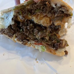 a hand holding a half eaten sandwich