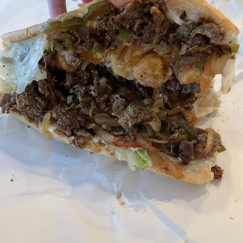 Po-Boy Express - a hand holding a half eaten sandwich - Sandwiches Near Me - Ocean Springs, Mississippi