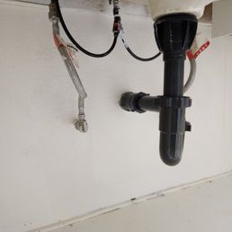Patched up wall under bathroom sink, previously a large rectangle hole exposing all pipes and plumbing