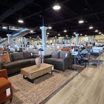 Living Spaces - A furniture store interior featuring sofas, a wooden coffee table, lamps, and various furniture displays in a spacious retail environment. - Home Decor Near Me - Lone Tree, Colorado