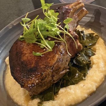 Amber Ox Public House - Pork chop and grits with collard greens - American Near Me - Williamsburg, Virginia Amber Ox Public House - Pork chop and grits with collard greens - American Near Me - Williamsburg, Virginia