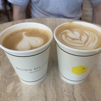 Brown Bee Coffee - Two cappuccinos in paper cups with Brown Bee Coffee logos - Coffee & Tea Near Me - Providence, Rhode Island