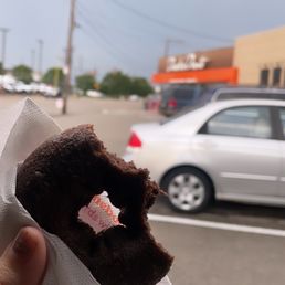 a person holding a donut in their hand a person holding a donut in their hand