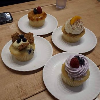 Molly's Cupcakes - Mixed Berry (front) Blueberry Cheesecake (left) Crème Brulee (back) Peach Cobbler (right) - Cupcakes Near Me - Chicago, Illinois Molly's Cupcakes - Mixed Berry (front) Blueberry Cheesecake (left) Crème Brulee (back) Peach Cobbler (right) - Cupcakes Near Me - Chicago, Illinois