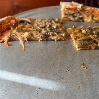 Flatbread Company - a half eaten pizza on a pan - Pizza Near Me - North Conway, New Hampshire