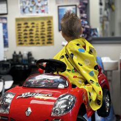 My son mid haircut staring at all the cool stuff to look at