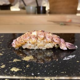a piece of sushi on a black plate a piece of sushi on a black plate