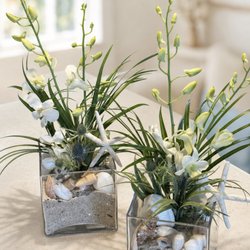 Pink Pelican Florist - A coastal Celebration of Life tribute with white flowers, blue hydrangeas, starfish, shells and Vero Beach sand.