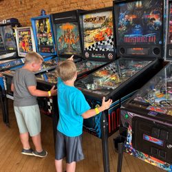 Henry W., playing one of a number of mechanical, yet electric pinball machines. He moved from one to another with abandon.