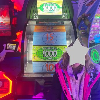 Monster Mini Golf - Won 1000 points and was only given 200. Employees said it is a known issue with the machine :/ - A girl with a pink and black jacket stands next to a skee-ball arcade machine, which displays ticket scores and bonus tickets. The arcade environment features colorful lighting and other game machines. - Mini Golf Near Me - Lafayette, Indiana