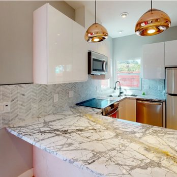 Basically Homes - a kitchen with marble countertops and stainless steel appliances - General Contractors Near Me Basically Homes - a kitchen with marble countertops and stainless steel appliances - General Contractors Near Me
