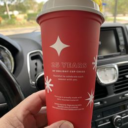 a hand holding a cup of coffee a hand holding a cup of coffee