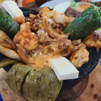Mi Abuelito - Lots of different meats are arranged with cactus, cheese, and jalapeno in a large mortar. - Mexican Near Me - Indianapolis, Indiana