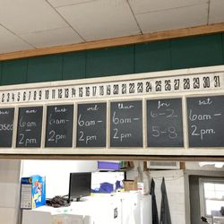 Delta Grill - Hours of operation posted above cash register