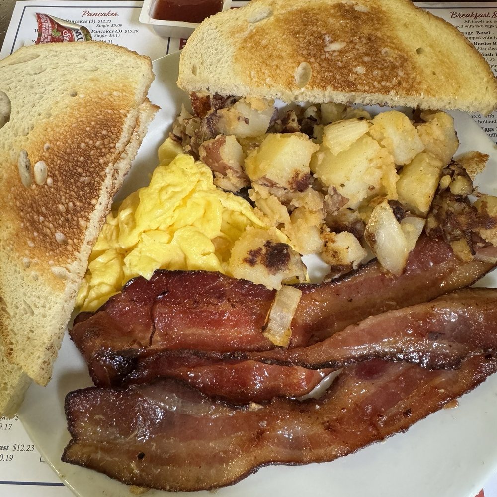 One scrambled egg with applewood smoked bacon, home fries and sourdough toast
